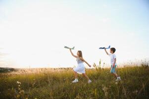 Active running kids with boy holding airplane toy. photo