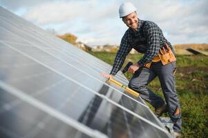 Professional worker installing solar panels on the metal construction, using different equipment, wearing helmet. Innovative solution for energy solving. Use renewable resources. Green energy. photo