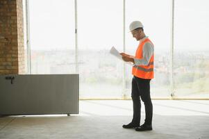 retrato de hombre arquitecto a edificio sitio. confidente construcción gerente vistiendo casco de seguridad. exitoso maduro civil ingeniero a construcción sitio con Copiar espacio. foto