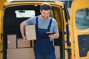 The courier brought the delivery of the box to the client. Courier service employee in uniform. photo