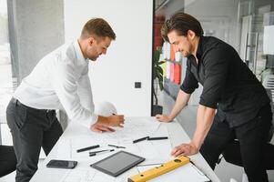 dos personas sentar en frente de construcción plan y hablar acerca de el arquitectura foto