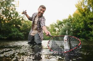 Fishing. Fisherman and trout. Fisherman on wild river. photo