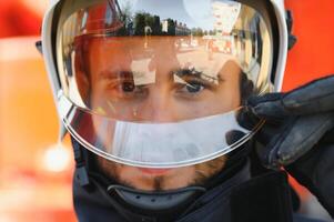 Photo of fireman with gas mask and helmet near fire engine