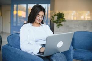 Freelance, business and e-commerce concept. Creative enthusiastic female journalist writing new article, typing on laptop, smiling, write-down project ideas, sit cafe, drink coffee working remote photo