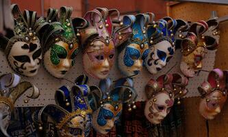 Traditional venetian masks on shelves in souvenirs shop in Venice, Italy. Beautiful carnival masks in variety of colours. Authentic and original Venetian full-face masks for Carnival. photo