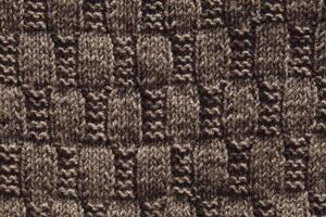 Background with gray knitted leaf shape, knitting pattern with cables. Top view, close-up. Handmade knitting wool photo