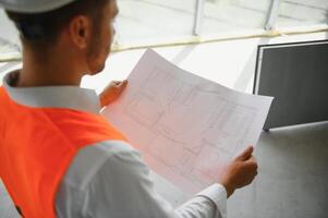 retrato de hombre arquitecto a edificio sitio. confidente construcción gerente vistiendo casco de seguridad. exitoso maduro civil ingeniero a construcción sitio con Copiar espacio. foto