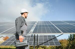 Professional worker installing solar panels on the metal construction, using different equipment, wearing helmet. Innovative solution for energy solving. Use renewable resources. Green energy. photo