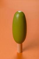 Wooden model of a tree with a green crown and trunk on a orange background photo