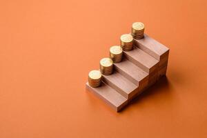 Conceptual composition of wooden steps with coins, model of a house photo