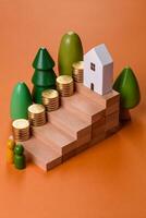 Conceptual composition of wooden steps with coins, model of a house photo