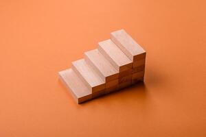 Conceptual composition of wooden steps with coins, model of a house photo