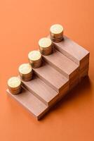 Conceptual composition of wooden steps with coins, model of a house photo