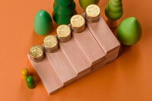 Conceptual composition of wooden steps with coins, model of a house photo