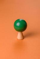 Wooden model of a tree with a green crown and trunk on a orange background photo