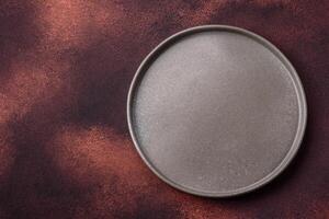 Empty ceramic round plate on dark textured concrete background photo