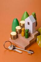 Conceptual composition of wooden steps with coins, model of a house photo