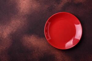 Empty ceramic round plate on dark textured concrete background photo