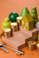 Conceptual composition of wooden steps with coins, model of a house photo