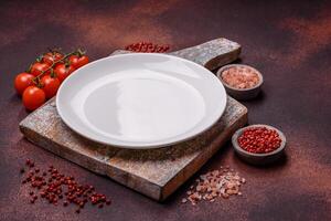 Empty ceramic round plate on dark textured concrete background photo