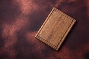 Empty rectangular wooden cutting board on textured concrete background photo