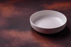 Empty ceramic round plate on dark textured concrete background photo