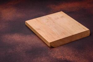 Empty rectangular wooden cutting board on textured concrete background photo