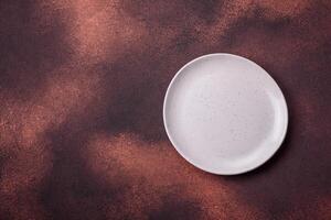 Empty ceramic round plate on dark textured concrete background photo