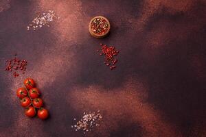 Empty concrete kitchen surface with salt, allspice and cherry tomatoes, copy space photo
