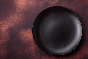 Empty ceramic round plate on dark textured concrete background photo