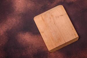 Empty rectangular wooden cutting board on textured concrete background photo