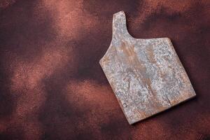 Empty rectangular wooden cutting board on textured concrete background photo