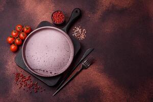 Empty ceramic round plate on dark textured concrete background photo