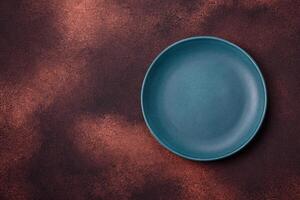 Empty ceramic round plate on dark textured concrete background photo
