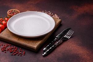 Empty ceramic round plate on dark textured concrete background photo