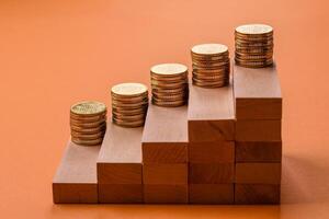 Conceptual composition of wooden steps with coins, model of a house photo