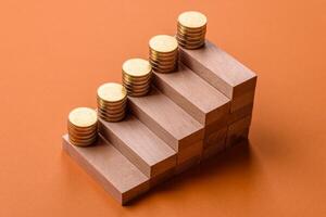 Conceptual composition of wooden steps with coins, model of a house photo