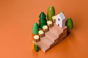 Conceptual composition of wooden steps with coins, model of a house photo