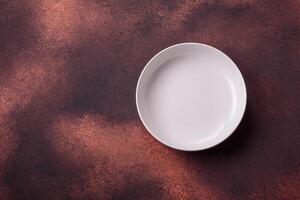 Empty ceramic round plate on dark textured concrete background photo