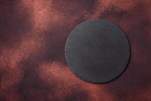 Empty ceramic round plate on dark textured concrete background photo