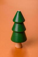 Wooden model of a tree with a green crown and trunk on a orange background photo