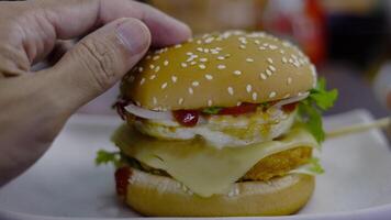 Man holds burger with hands on background in cafe. video