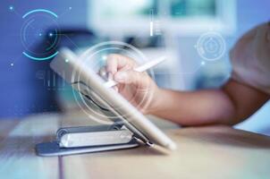 Hand of woman using pencil writing on digital tablet. Creative work concept. with HUD GUI head up display interface Design element. Selective focus shallow depth of field photo