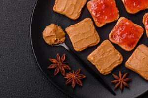 Delicious nutritious sandwiches with peanut butter, strawberry jam photo