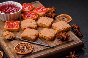 Delicious nutritious sandwiches with peanut butter, strawberry jam photo