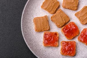 Delicious nutritious sandwiches with peanut butter, strawberry jam photo