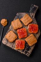 Delicious nutritious sandwiches with peanut butter, strawberry jam photo