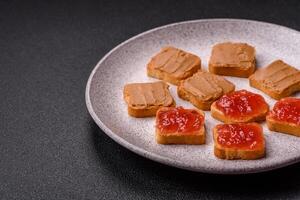 Delicious nutritious sandwiches with peanut butter, strawberry jam photo