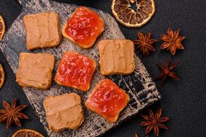 Delicious nutritious sandwiches with peanut butter, strawberry jam photo
