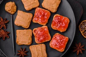 Delicious nutritious sandwiches with peanut butter, strawberry jam photo